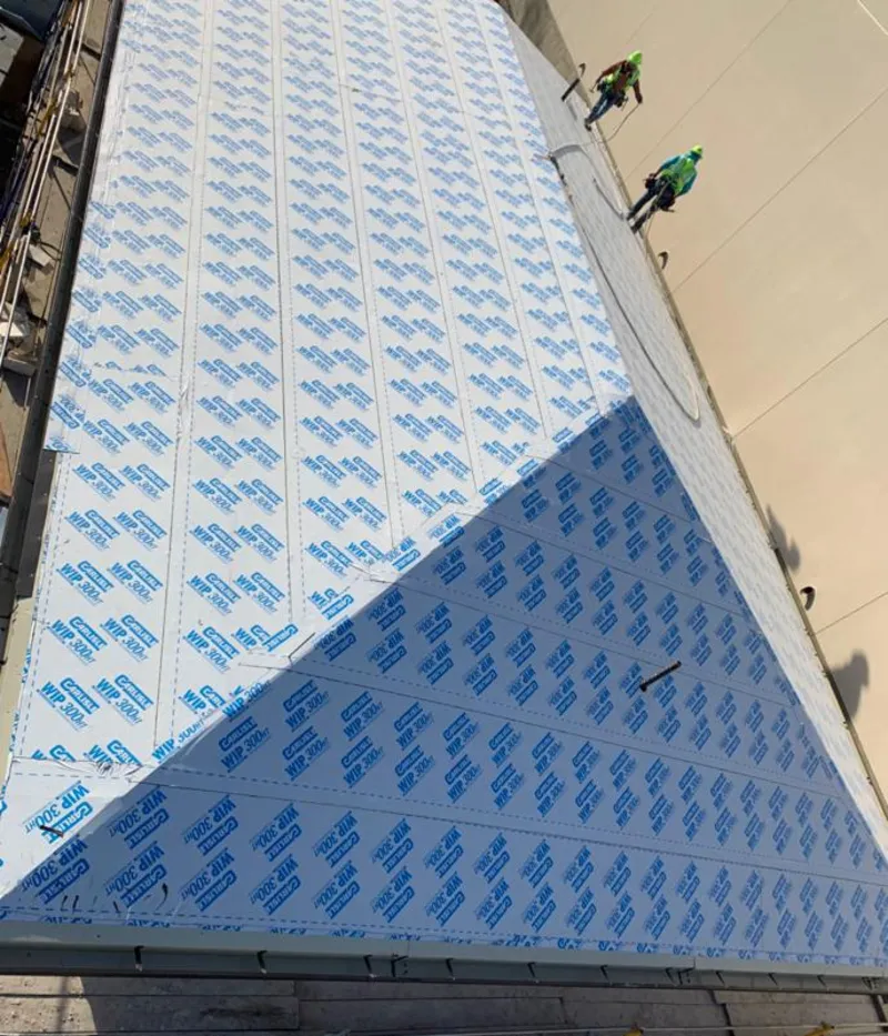 Professional roofers installing underlayment on a metal roof in Bowling Green